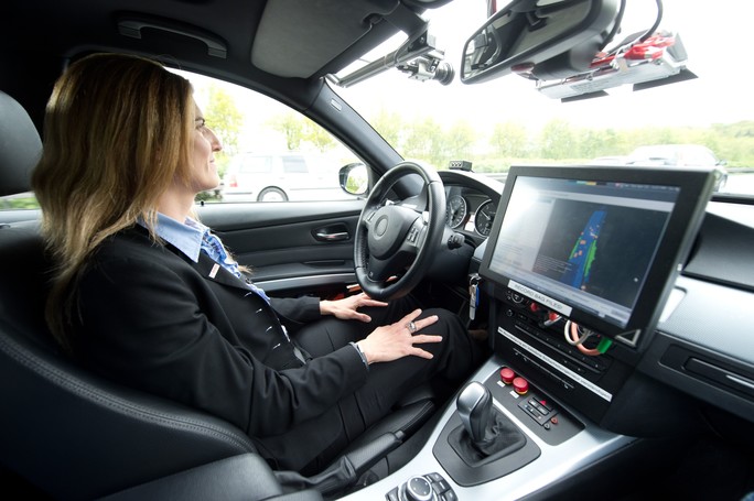 Junge Frau in einem Testfahrzeug für automatisiertes Fahren 